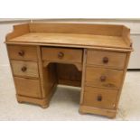 A Victorian pine kneehole washstand, the three quarter galleried top over a central drawer,