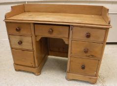 A Victorian pine kneehole washstand, the three quarter galleried top over a central drawer,