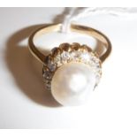 A gold-mounted (un-marked) pearl and diamond dress ring, the central pearl (approx size 17),