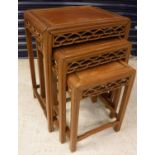 A nest of three Chinese hardwood occasional tables with fretwork carved frieze raised on moulded