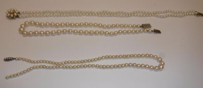 A two strand pearl necklace with pearl set flower head clasp, 34 cm long,