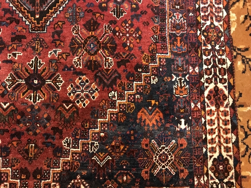 A Persian rug with centre lozenge medallion on a red ground, - Image 5 of 17