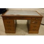 An early 20th Century walnut kneehole desk,
