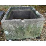 A large natural stone rectangular trough raised on four block bases,