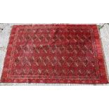 A Persian rug with all over repeating lozenge medallions on a red ground,