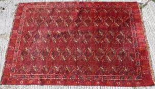 A Persian rug with all over repeating lozenge medallions on a red ground,