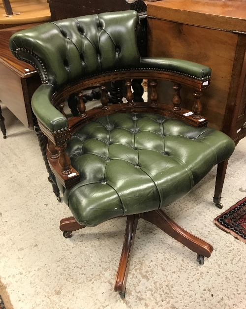 A modern buttoned leather upholstered swivel office chair in the Victorian style,