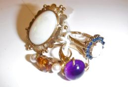 A collection of four various 9 carat gold mounted rings including an oval cabochon cut opal within