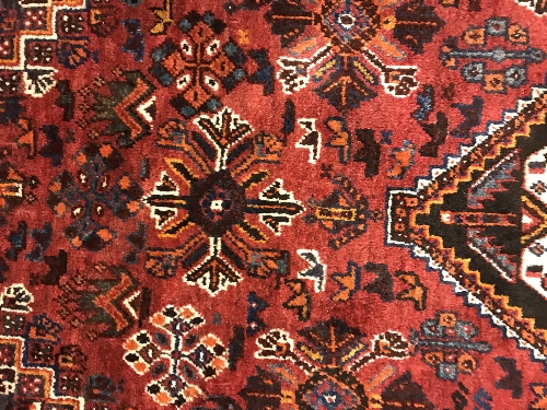 A Persian rug with centre lozenge medallion on a red ground, - Image 15 of 17