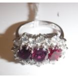 An 18 carat white gold mounted ladies dress ring set with three central rubies within a band of