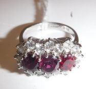 An 18 carat white gold mounted ladies dress ring set with three central rubies within a band of