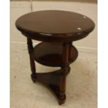 A mahogany occasional table of two circular tiers on turned supports,