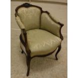 A Victorian walnut framed and carved tub chair in the Louis XV taste raised on cabriole front legs