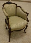 A Victorian walnut framed and carved tub chair in the Louis XV taste raised on cabriole front legs