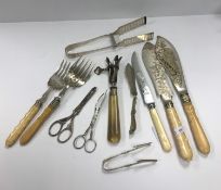 A small quantity of plated cutlery to include asparagus servers, bone handled anchovy tongs,
