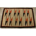 A modern Navaho rug, the central panel set with geometric orange and black design on a cream ground,