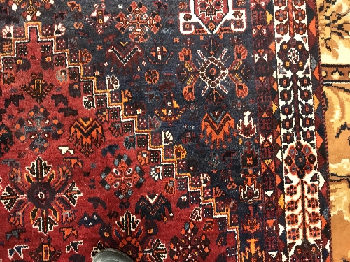 A Persian rug with centre lozenge medallion on a red ground, - Image 12 of 17