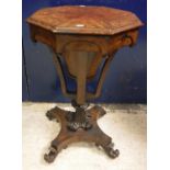 A Victorian figured mahogany octagonal trumpet shaped work table on double lyre supports to scroll