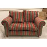 A pair of Duresta green, red and gold striped upholstered scroll arm two seat sofas,
