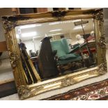 A modern rectangular swept gilt framed wall mirror with bevel edge plate 92 cm x 67 cm