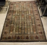 A Persian rug, the central panel set with tiled design, each with stylised floral decoration,
