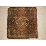 A Caucasian rug, the central panel set with lozenge shaped medallion on a salmon pink ground,