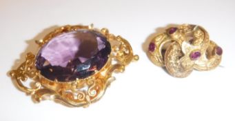 An amethyst and yellow metal mounted brooch/pendant the central cut stone 3 cm x 2.