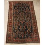 A Hamadan rug, the central panel set with all over stylised floral decoration on a dark blue ground,