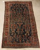 A Hamadan rug, the central panel set with all over stylised floral decoration on a dark blue ground,