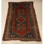 A Caucasian rug, the central panel set with rectangular medallion on a red ground,