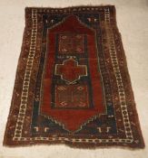A Caucasian rug, the central panel set with rectangular medallion on a red ground,