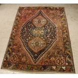 A Persian rug, the central panel with repeating medallions on a blue ground,