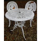 A white painted metal garden table and two chair in the Victorian style