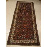 A Malayer runner, the central panel set with stylised floral motifs on a dark blue ground,