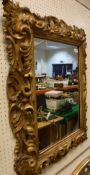 A 19th Century carved gilt wood and gesso framed wall mirror in the Florentine manner with all over