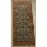 A Qum silk rug, the central panel set with all-over floral decoration on an aquamarine ground,