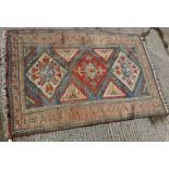 A Turkish carpet, the central panel set with three repeating medallions on a blue ground,