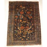 A Hamadan rug, the central panel set with stylised floral decoration on a dark ground,