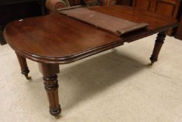 A Victorian mahogany rounded rectangular dining table on turned and fluted legs to casters 114 cm