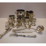 A collection of silver plated bottle and condiment holders and a toast rack, assorted cutlery,