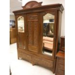 A Victorian walnut and carved two piece bedroom suite comprising three door wardrobe with two