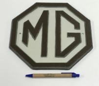 A modern painted cast metal sign "MG", a