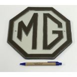 A modern painted cast metal sign "MG", a