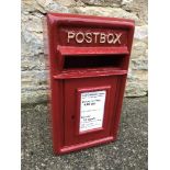 A modern reproduction metal red postbox,