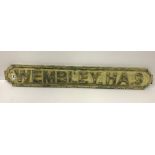 A modern wooden sign inscribed "Wembley HA9",