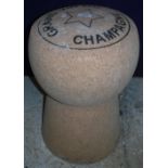An over-sized cork stool inscribed "Grand Vin du Champagne",