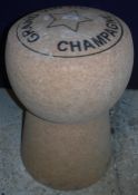 An over-sized cork stool inscribed "Grand Vin du Champagne",