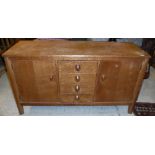 A Gordon Russell oak sideboard, the plain top above a bank of four drawers,