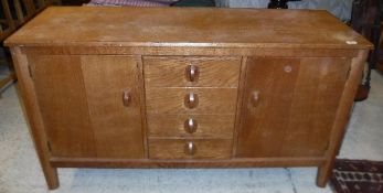 A Gordon Russell oak sideboard, the plain top above a bank of four drawers,