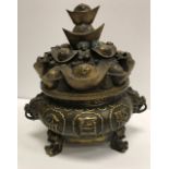 A Chinese patinated brass koro or censer with pierced hat decorated cover,